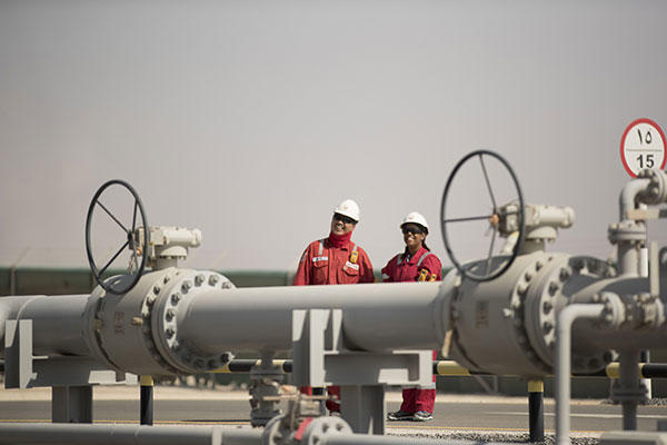 Hommes devant un oléoduc - industrie pétrolière